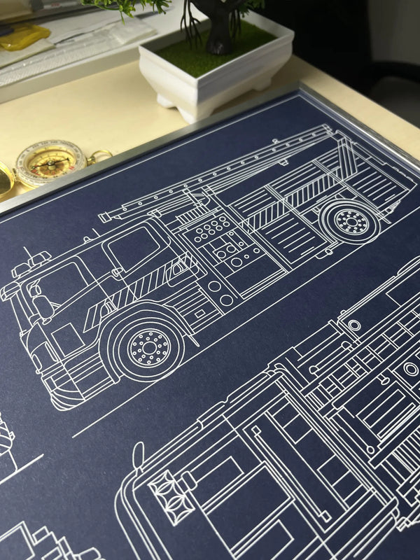 Close-up of framed fire engine blueprint showing side view with ladder and wheels, white line drawing