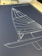 A close-up of a dark blue print featuring a white line drawing of a sailboat and the text 'Single-handed Slooping' and 'RCA-7'.
