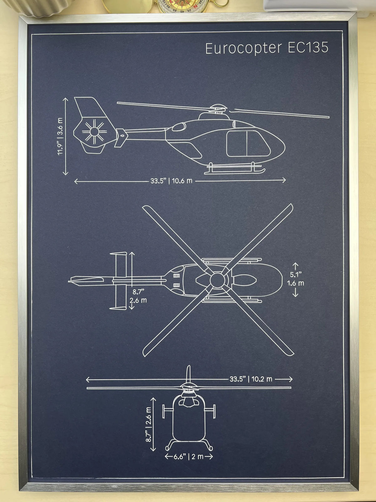 Framed Eurocopter EC135 helicopter blueprint showing side, top and front views, silver metal frame