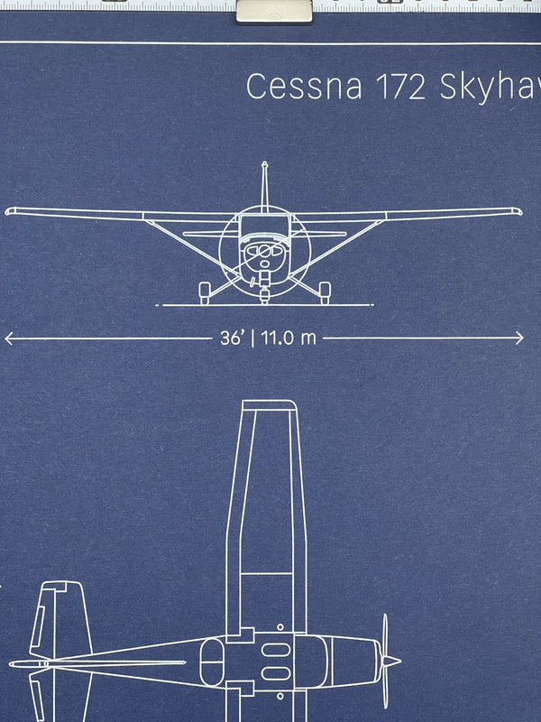Close-up of Cessna 172 Skyhawk blueprint showing front view with 36 ft wingspan, white ink on navy paper